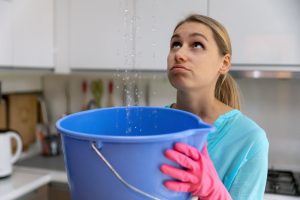 Female with water bucket, ready for house flood cleanup in Utah.